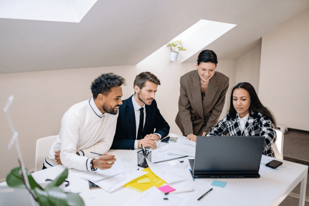 A group of people looking at the laptop and smiling