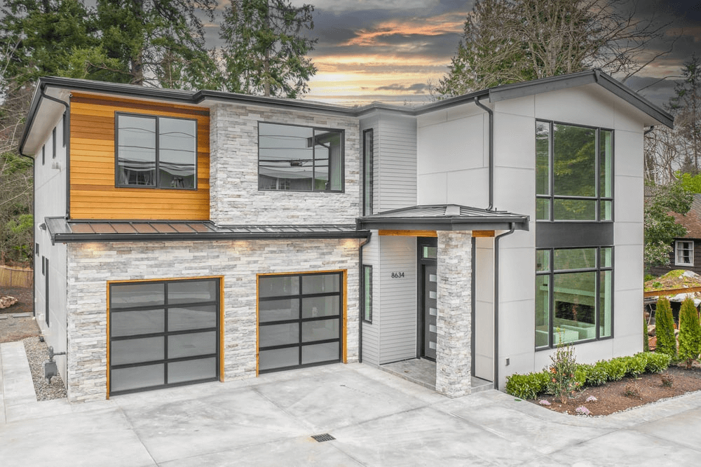 A modern home with two garages and a driveway.