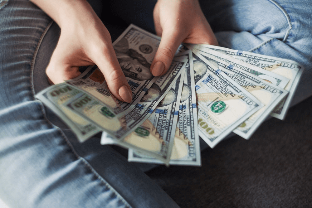 A woman sitting and holding the cash in her hands