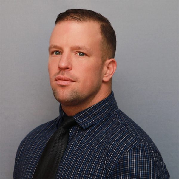 A man in a blue shirt and black tie.