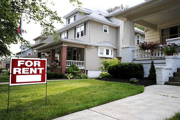 A “for rent” sign in front of a house