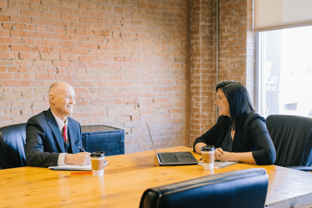 Two people talking inside an office