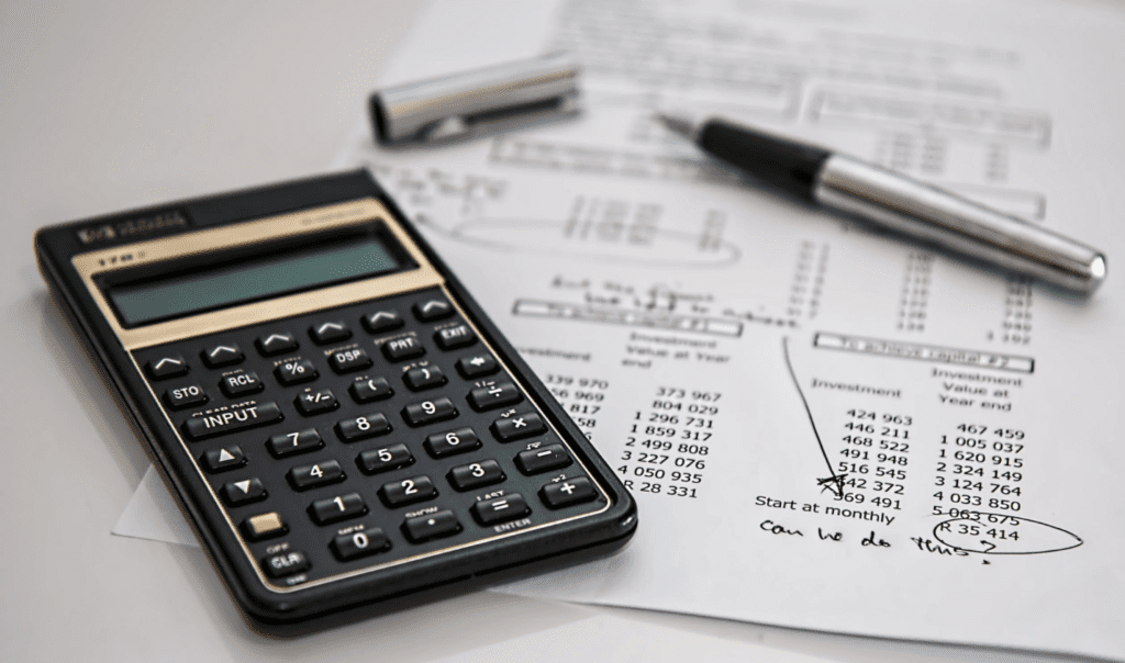 A photo showing a calculator resting on top of a document.