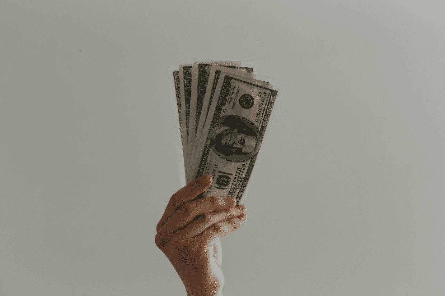 A photo showing a person holding American banknotes.