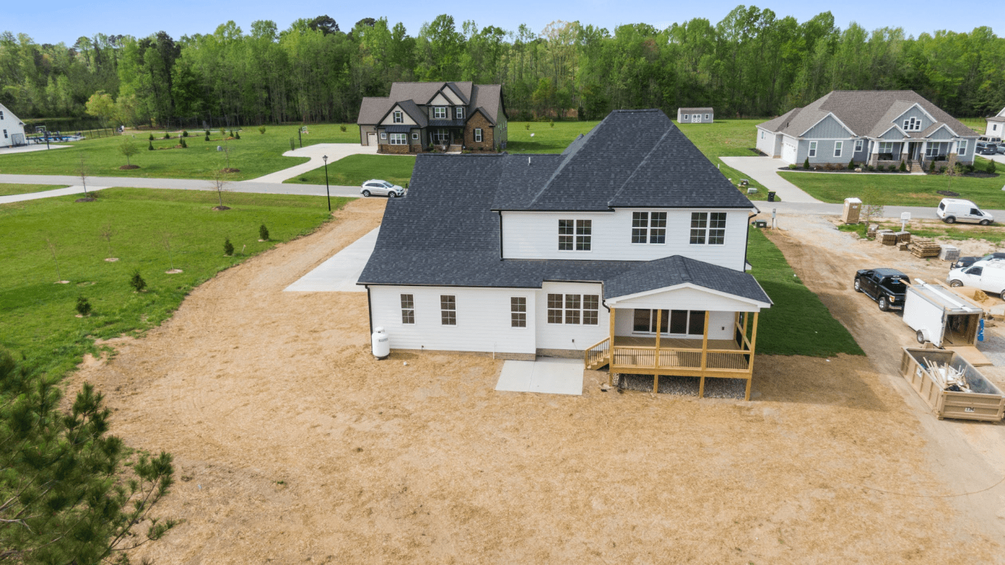 A photo showing a two-story home surrounded by sand.