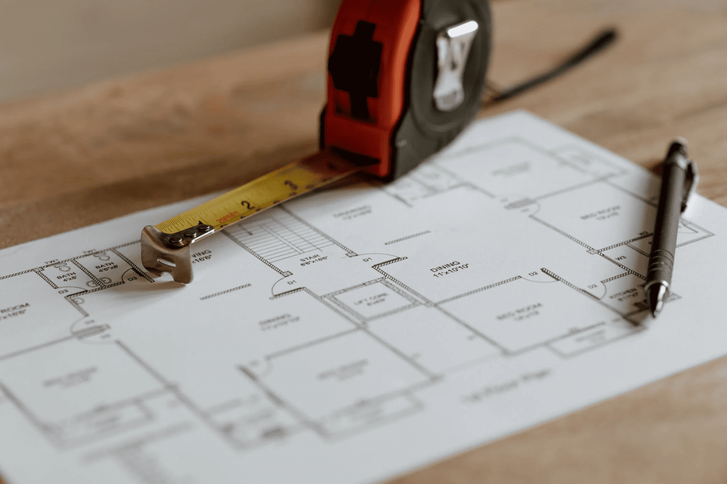 A photo showing a measuring tape resting on top of a document.