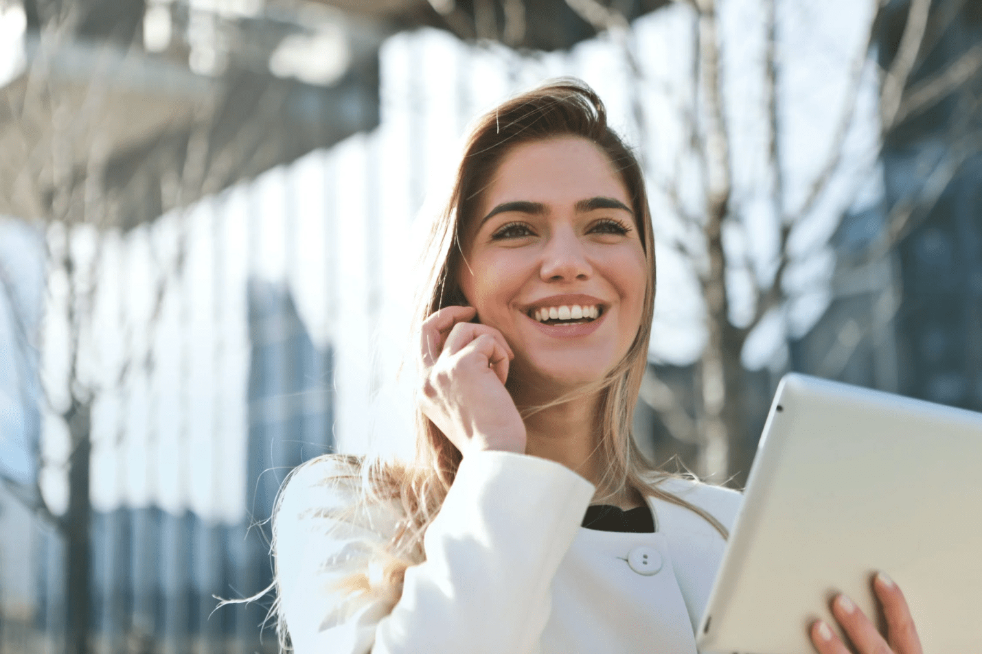  A photo showing a woman talking on the phone and holding a smart tablet.