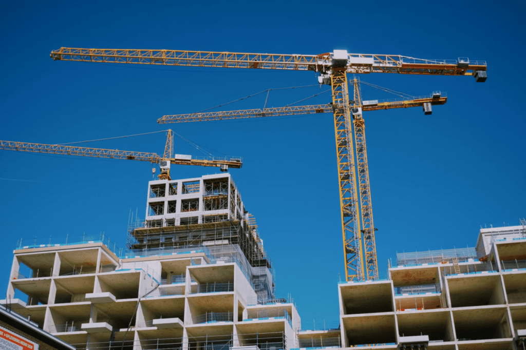 A photo showing cranes at a construction site.