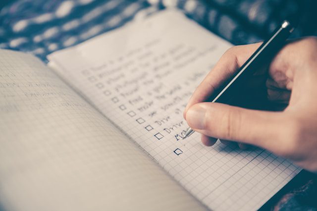 A person sitting at a desk, creating a checklist