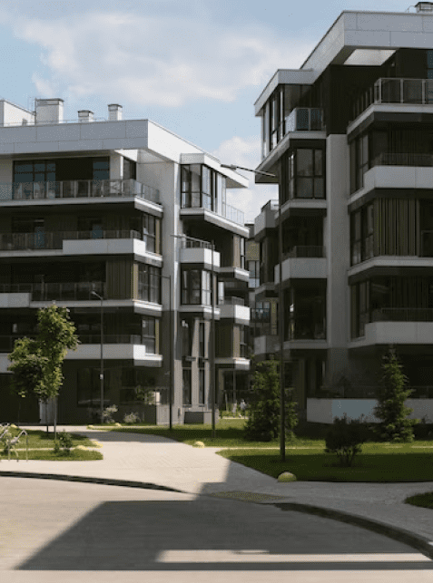 Modern apartment buildings with large windows and balconies in a landscaped urban area.