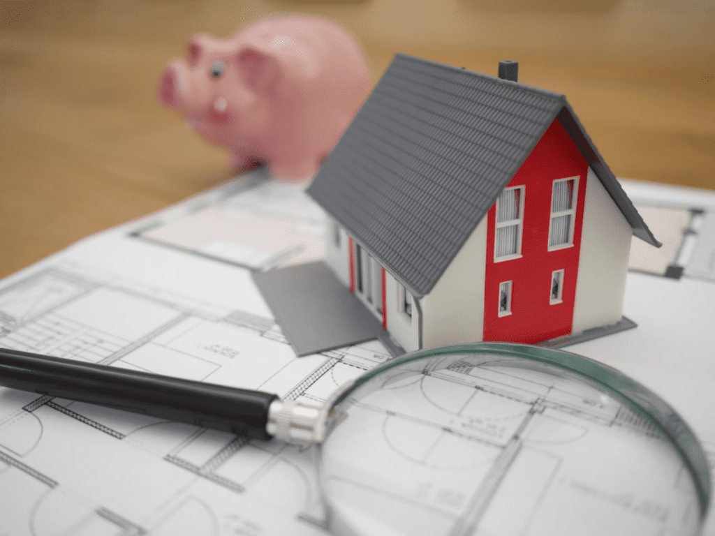 A photo showing a model of a house resting on top of a floor plan.