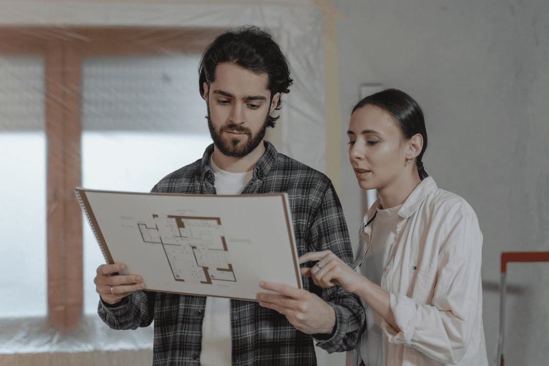 Two people discussing a new construction floor plan