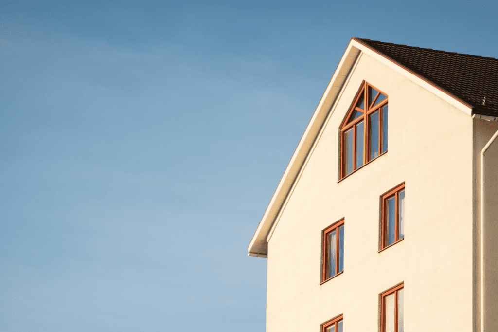 House with beige paint and wooden window frames.