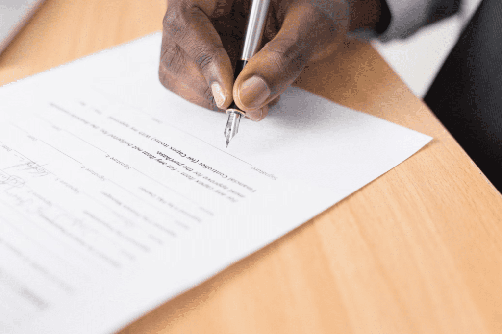 A photo showing a person holding a fountain pen at a desk