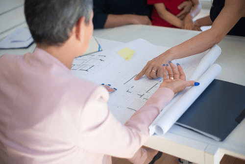 A person reviewing a blueprint before granting a new construction loan