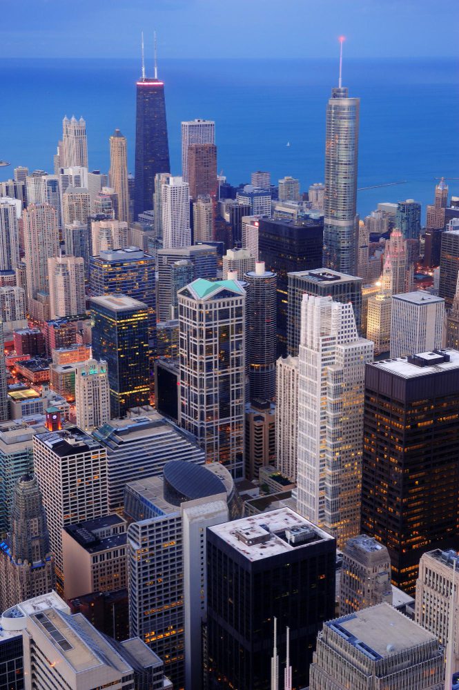 Aerial view of a densely built cityscape with skyscrapers at dusk.