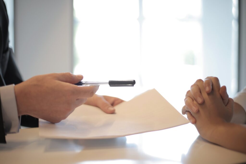 A person handing over documents for a loan.