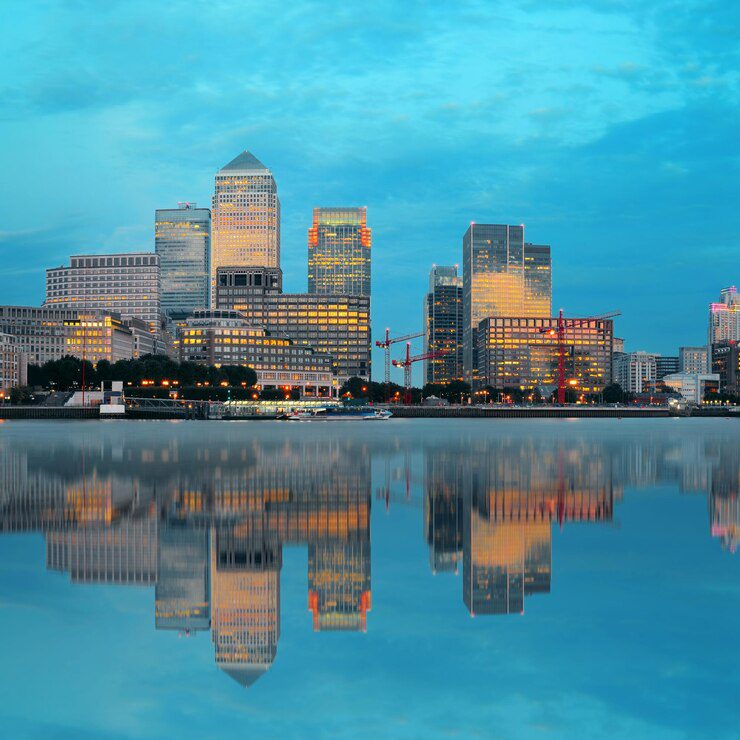 City skyline at dusk with calm water reflection.