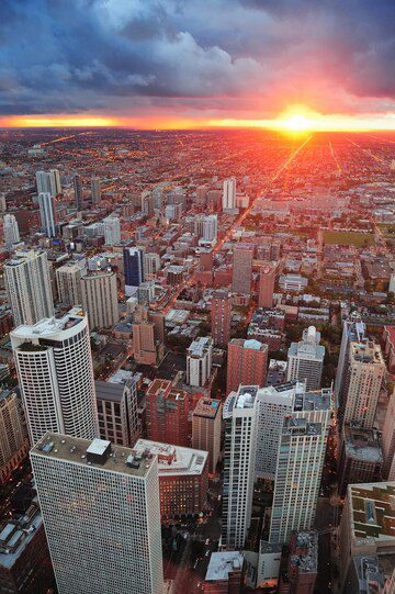 Aerial view of a city skyline at sunset with clouds in the sky.