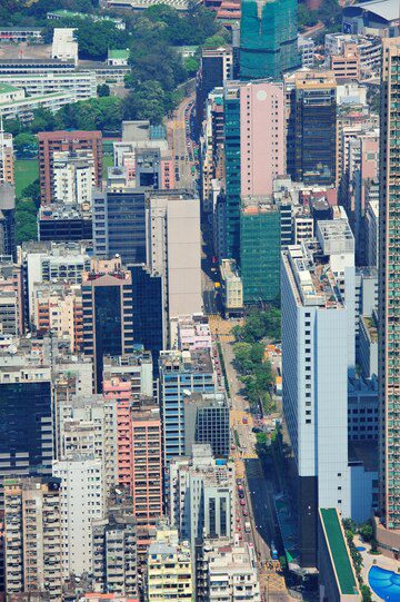 Aerial view of a dense urban area with closely packed high-rise buildings and a winding road.