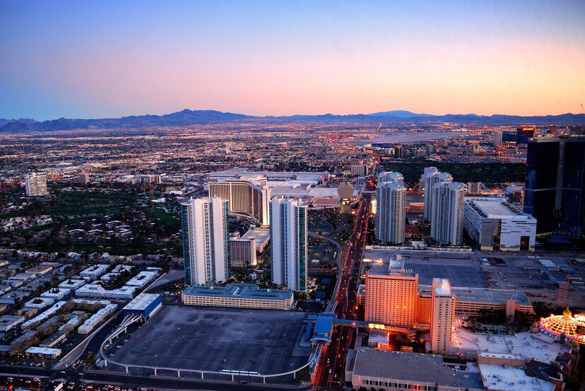 Aerial view of las vegas at twilight with city lights starting to illuminate the skyline.