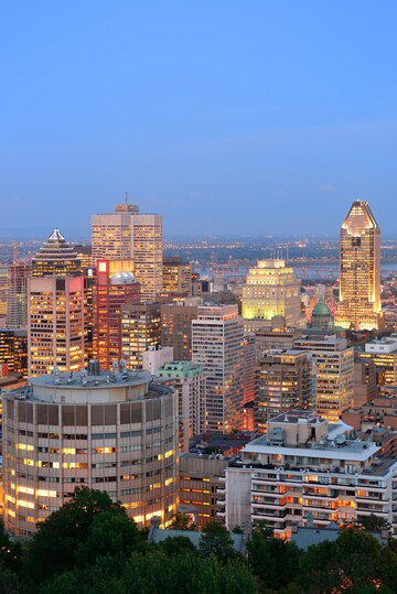 Twilight cityscape with illuminated buildings and a fading sky.