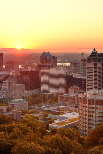 City skyline at sunset with warm hues in the sky.