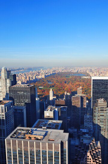 Aerial view of a city skyline with central park amidst autumn foliage.