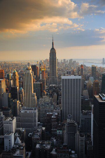 Aerial view of a city skyline with the empire state building at sunset.