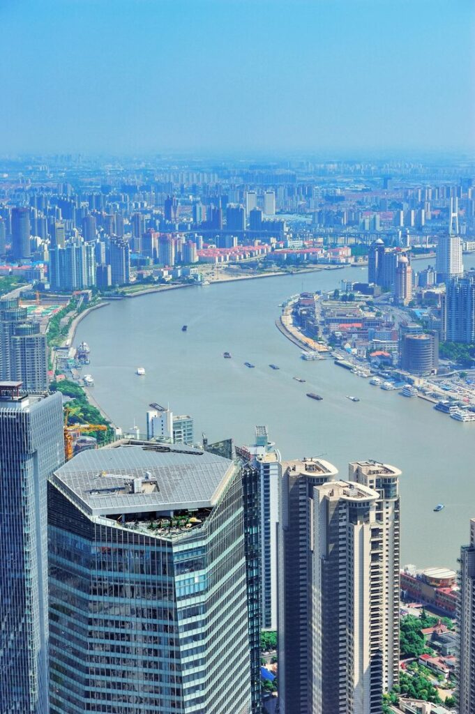 Aerial view of a modern cityscape with skyscrapers along a winding river.