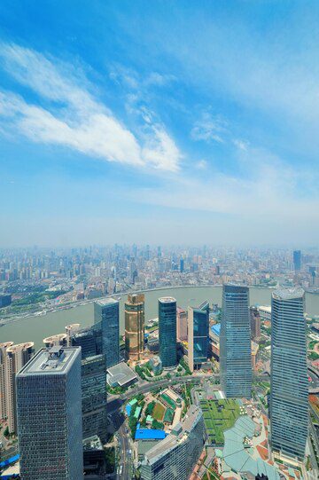 Aerial view of a modern city skyline with tall skyscrapers under a clear blue sky.