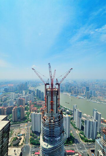 High-rise building under construction in a bustling cityscape with river views.