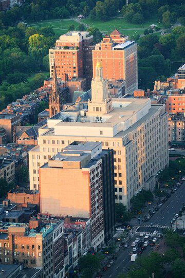 Aerial view of a cityscape with buildings and streets at dusk.