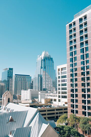 Urban skyline with a mix of modern high-rise buildings under a clear blue sky.