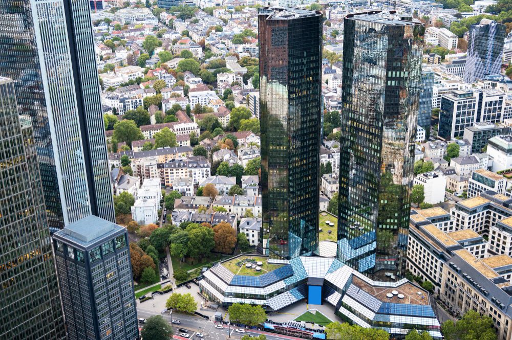 Aerial view of modern skyscrapers juxtaposed with traditional housing in an urban landscape.