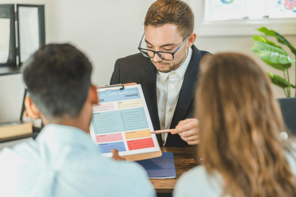 An investor showing a checklist to a couple.