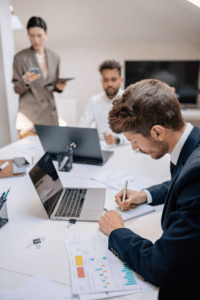 A group of people, including a hard money lender and real estate investor clients, gathered around a table to discuss documents