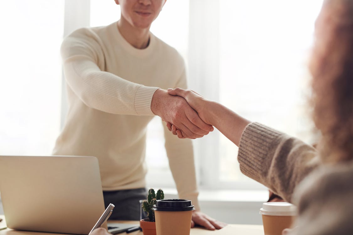 Two individuals shaking hands after a successful loan acquisition