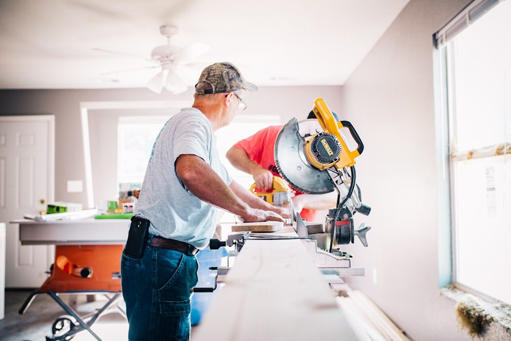 A worker using a saw in a house