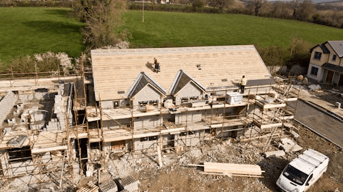 An aerial photo of the construction of a brown 3-story house