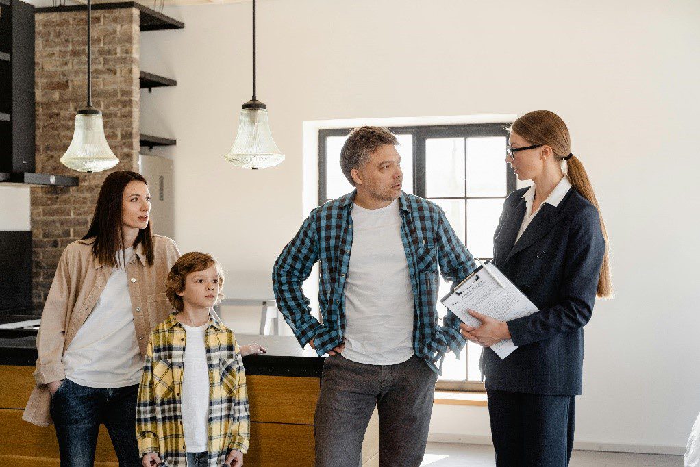 A woman speaking to a family