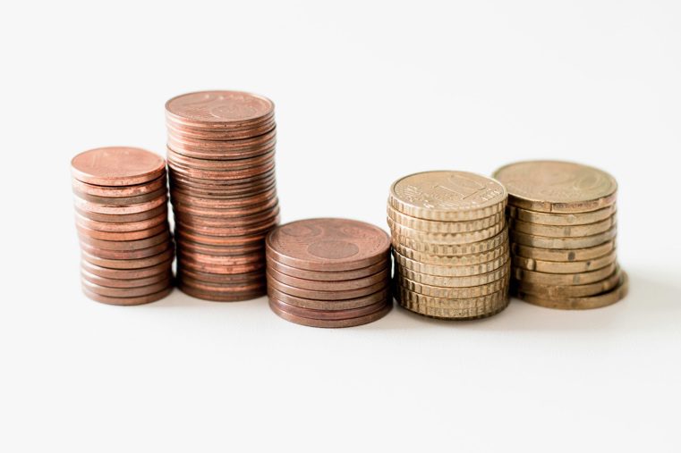 Stack of bronze and gold coins on a white surface