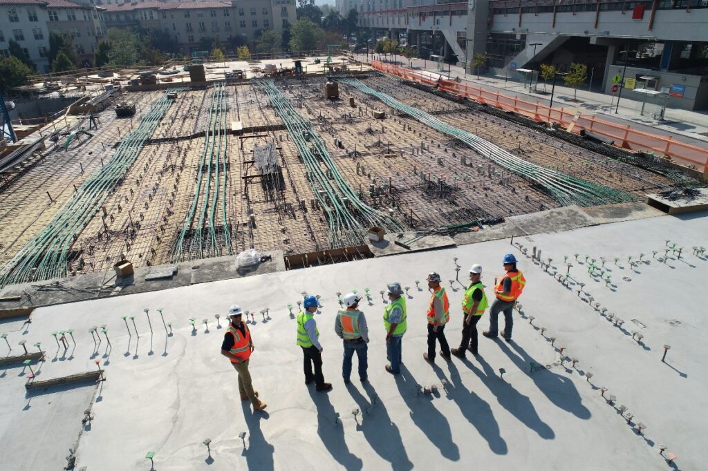 Several people are standing at a construction site.