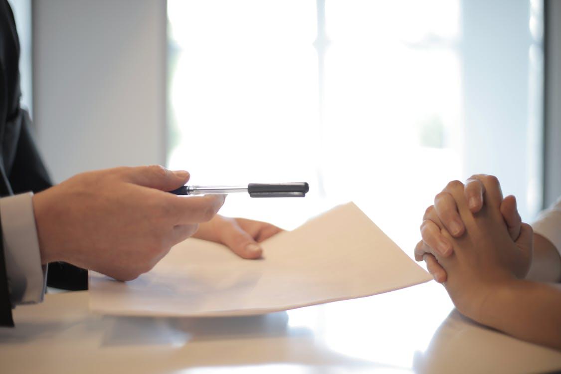 A person signing papers with a professional.