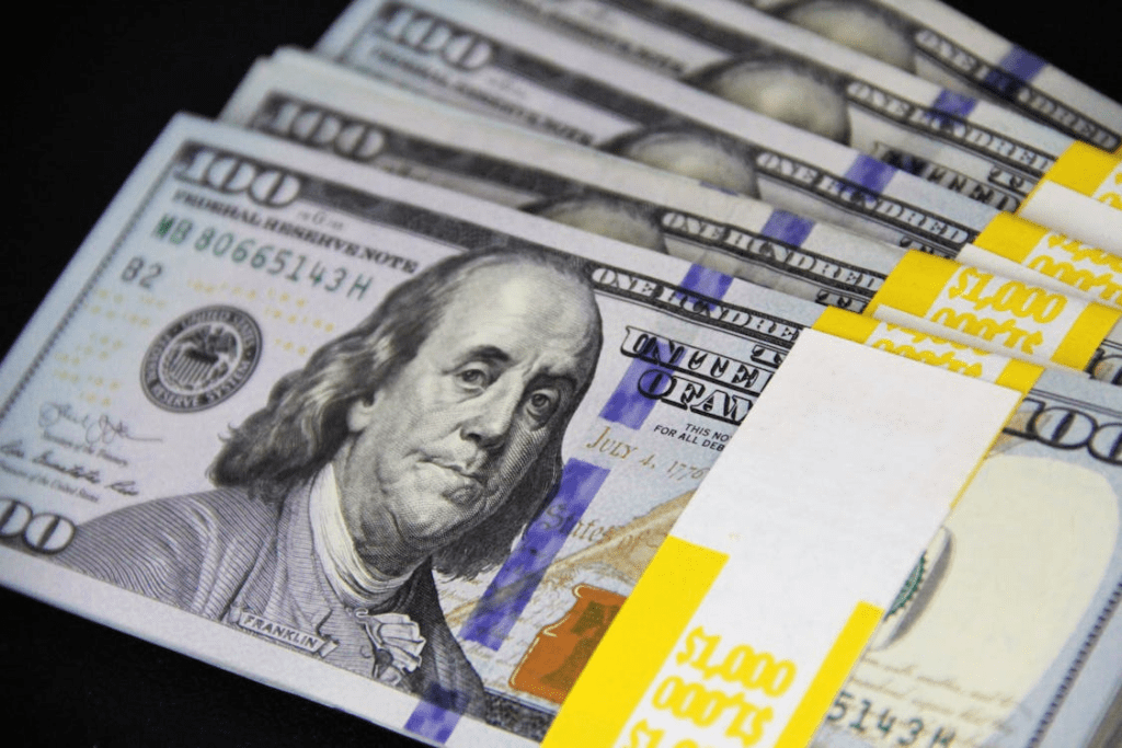 Bundles of 100-dollar banknotes on a black surface