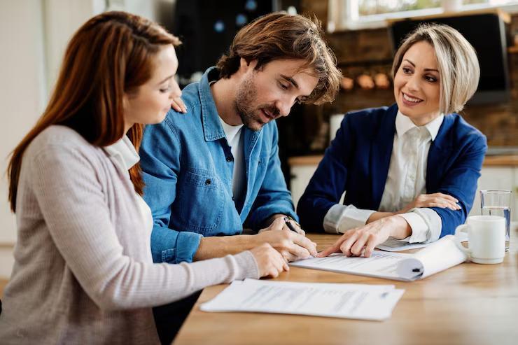 Young couple signing a lease agreement with a real estate agent