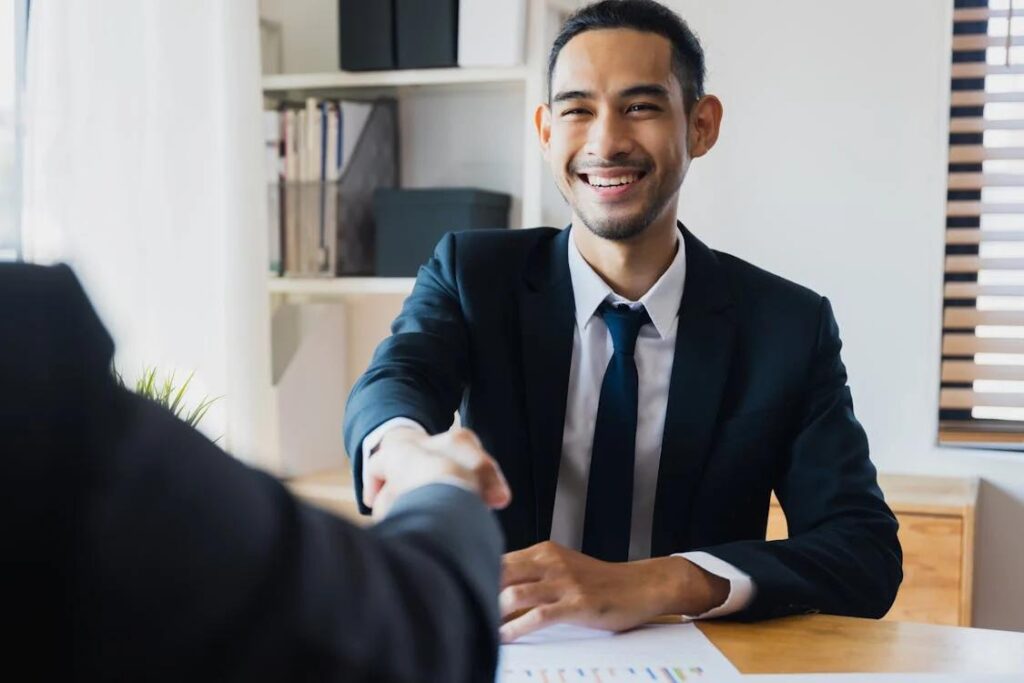 Two people shaking hands over a contract