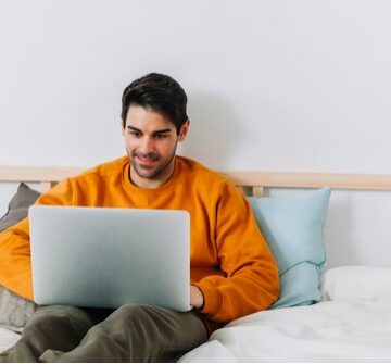 Cheerful man browsing on his laptop 