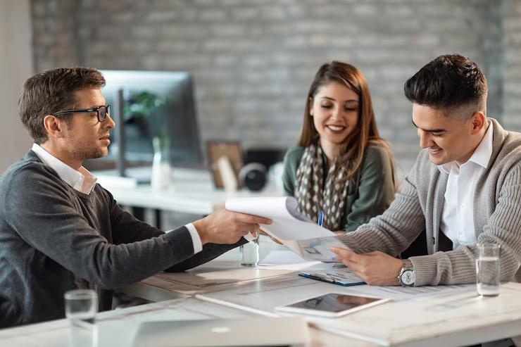 Happy couple signing a contract during a meeting 