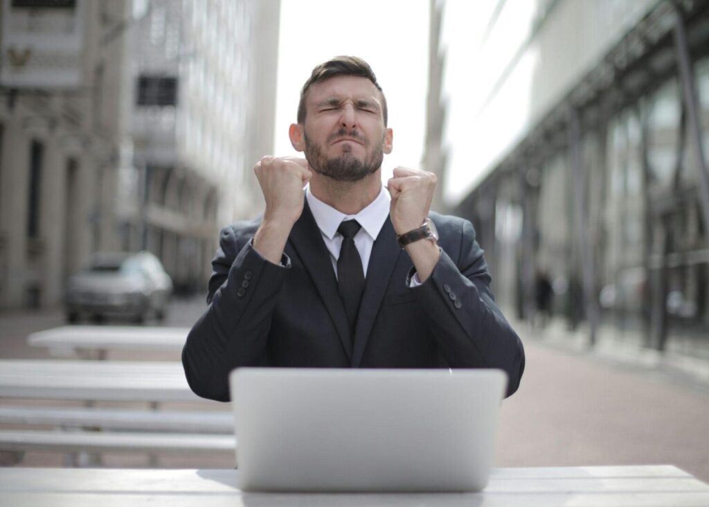 A man in a black suit looks distressed